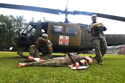 Staff Sgt. Matthew Ortiz (left), infantryman with the New York Army National Guard’s Alpha Company, 1st Battalion, 69th Infantry Regiment, performs simulated first-aid on a mannequin during the casualty medical evacuation portion of the competition.